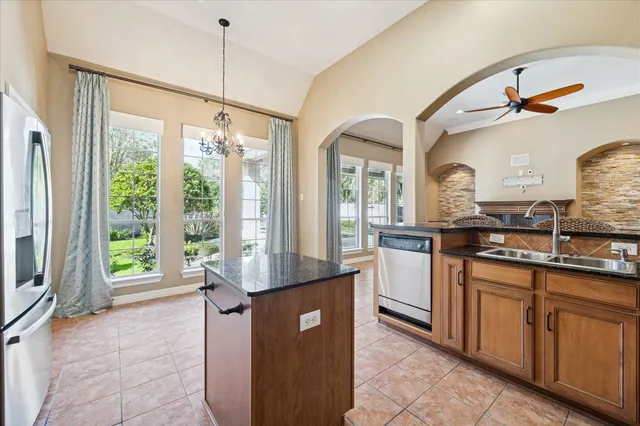 a kitchen with kitchen island a counter top space appliances and a large window