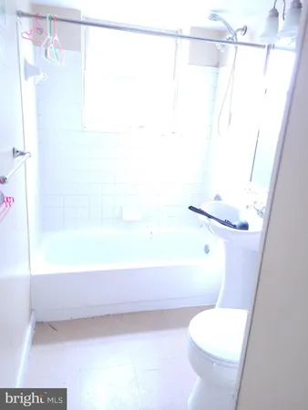 a white toilet sitting next to a bath tub