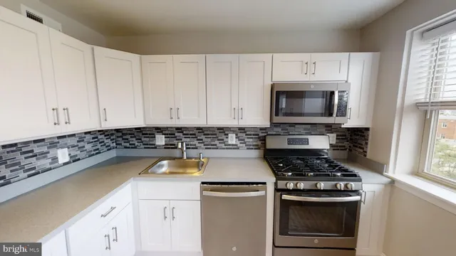 a kitchen with a stove a sink and a microwave