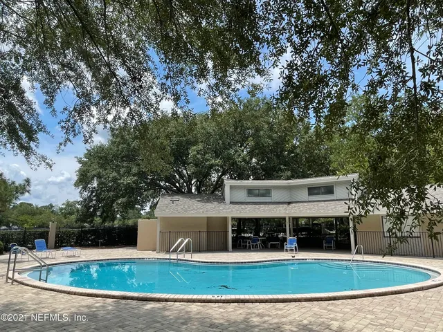 a view of a house with a backyard and a tree