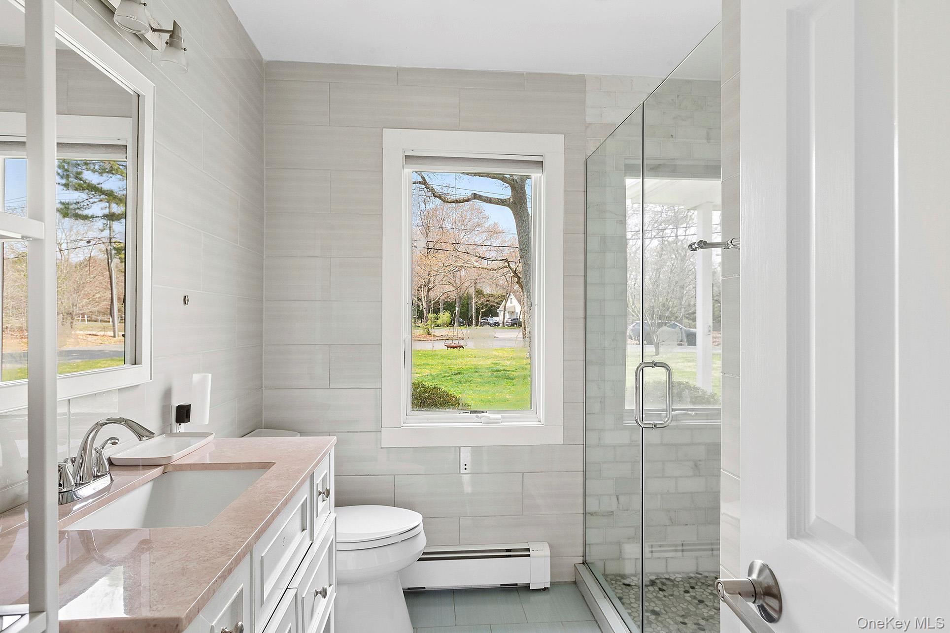 3 Jones Road Hampton Bays, NY 11946 - Photo 11 of 19 a bathroom with a granite countertop toilet a sink and a mirror