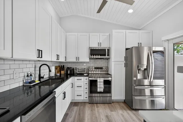a kitchen with stainless steel appliances granite countertop a refrigerator stove and sink