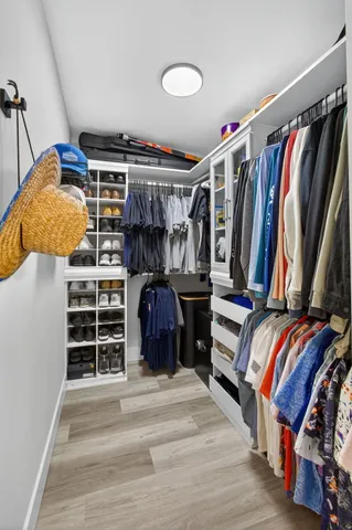 a view of walk in closet with clothes and shoes