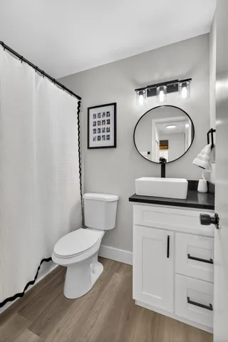 a bathroom with a toilet a sink and a mirror