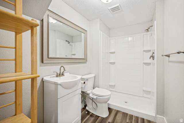 5529 Ridge Hollow Way Kearns, UT 84118 - Photo 19 of 23 Compact bathroom featuring a white vanity with integrated sink, brushed nickel faucet, a framed mirror, and a white shower-tub combination with tile-look surround