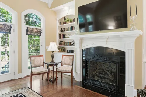 a kitchen with kitchen island granite countertop a stove a sink a dining table and chairs with wooden floor