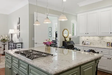 a kitchen with a sink a stove and chairs