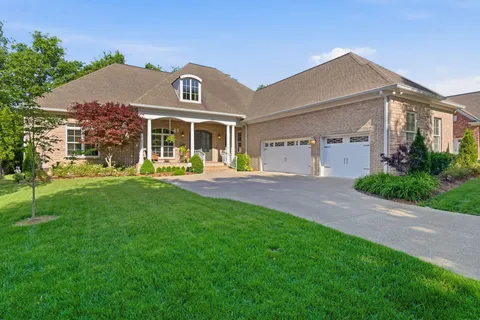 a front view of a house with a yard and potted plants