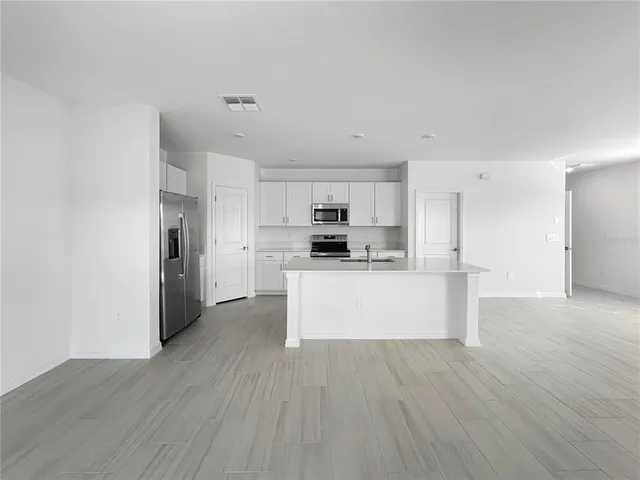 a view of kitchen with refrigerator stove microwave and cabinets