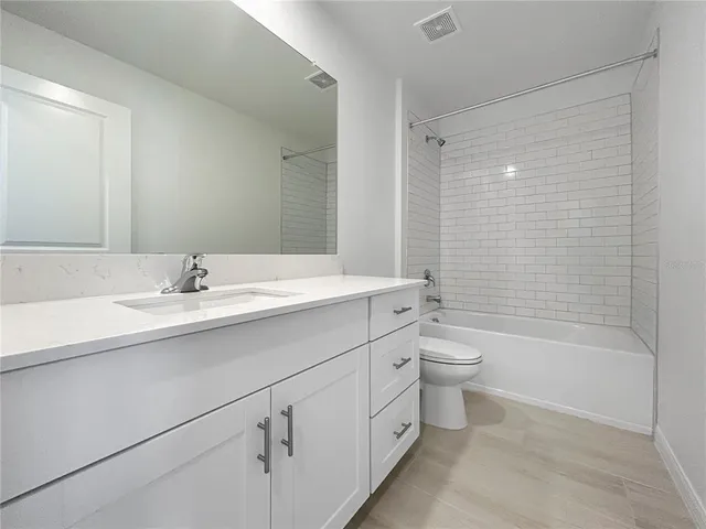 a bathroom with a double vanity sink toilet mirror and bathtub