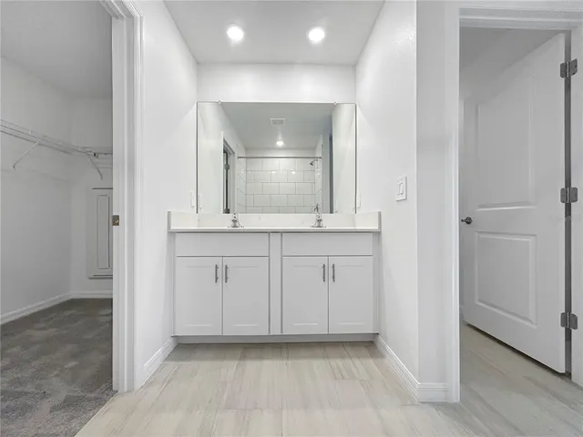 an empty room with mirror and cabinets
