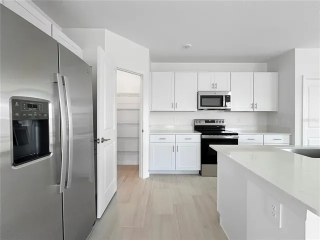 a kitchen with cabinets stainless steel appliances and a counter space