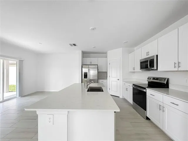 a kitchen with stainless steel appliances kitchen island granite countertop a sink and cabinets