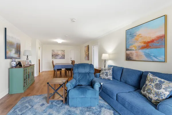 a living room with furniture kitchen view and a window