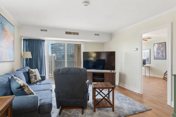 a living room with furniture a flat screen tv and a floor to ceiling window