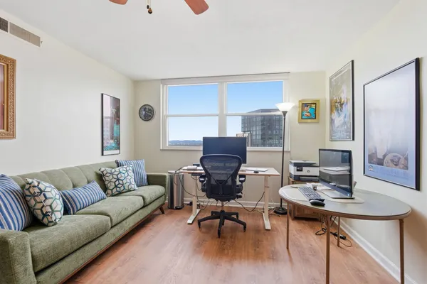 a view of a livingroom with workspace and a window