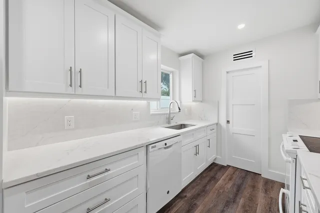 a kitchen with a sink cabinets and wooden floor
