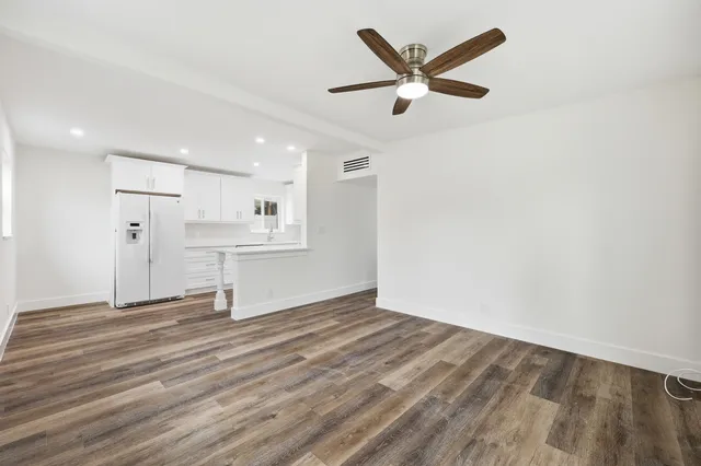 a view of empty room with wooden floor and window