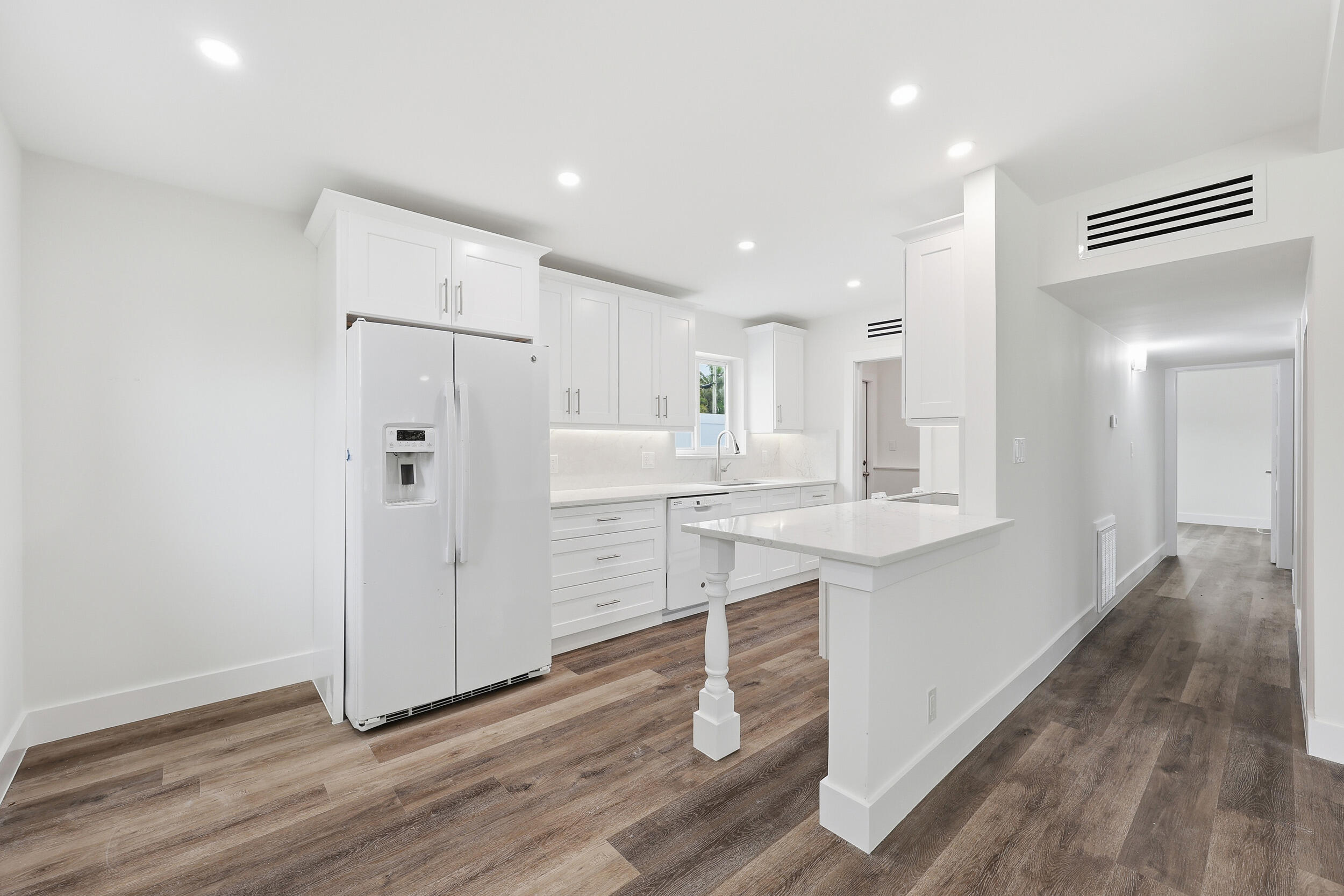 403 Todd Street Jupiter, FL 33458 - Photo 10 of 30 a kitchen with white cabinets and stainless steel appliances