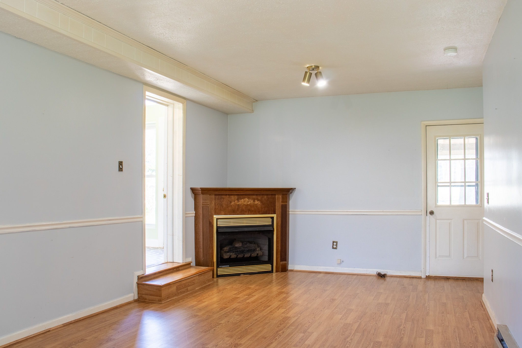 1623 Friendship Road Cross Plains, TN 37049 - Photo 42 of 56 an empty room with wooden floor and fireplace
