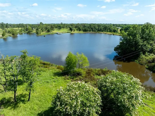 an aerial view of lake and residential houses with outdoor space