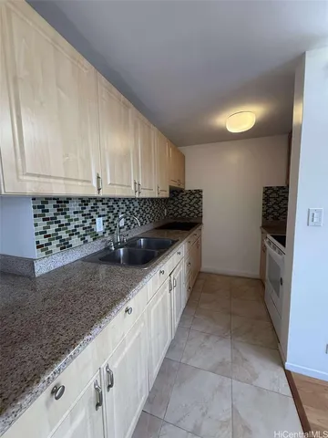 a kitchen with stainless steel appliances granite countertop a sink a stove and a refrigerator