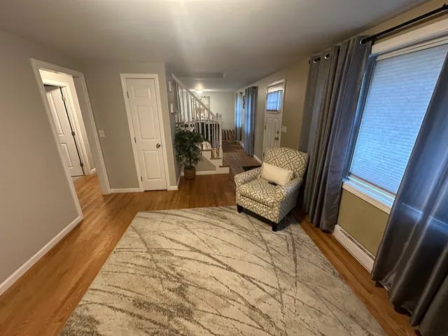 a bedroom with a bed wooden floor and couch