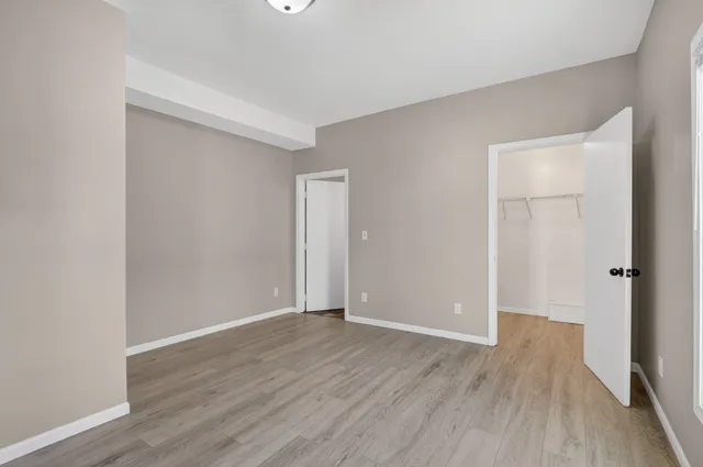 a view of an empty room with wooden floor