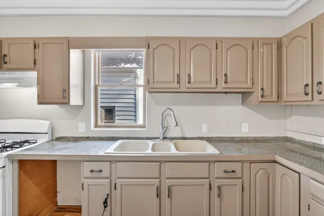 a kitchen with granite countertop a sink and a stove