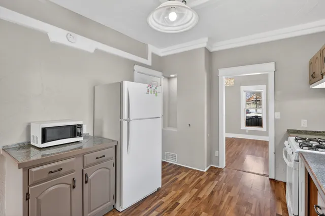 a kitchen with cabinets and wooden floor