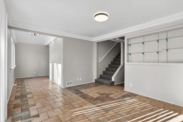 a view of an empty room with stairs and ventilation