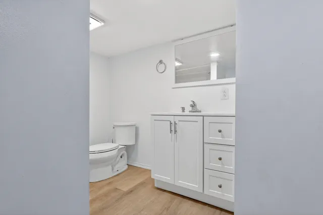 a bathroom with a toilet a sink a vanity and mirror