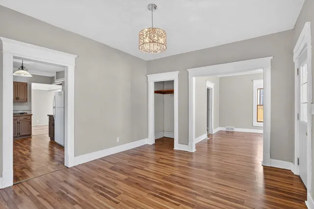 a view of a hallway with wooden floor and workspace