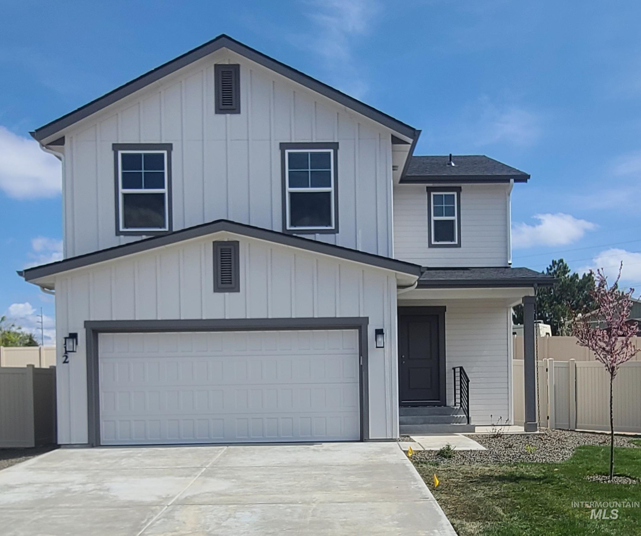 Modern farmhouse style home featuring concrete driveway, board and batten siding, and roof with shingles