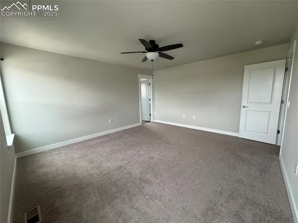 an empty room with a ceiling fan and a window
