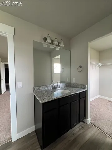 a bathroom with a granite countertop sink a light fixture and a mirror