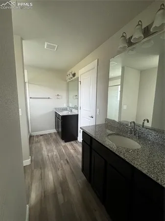 a bathroom with a granite countertop sink vanity and mirror