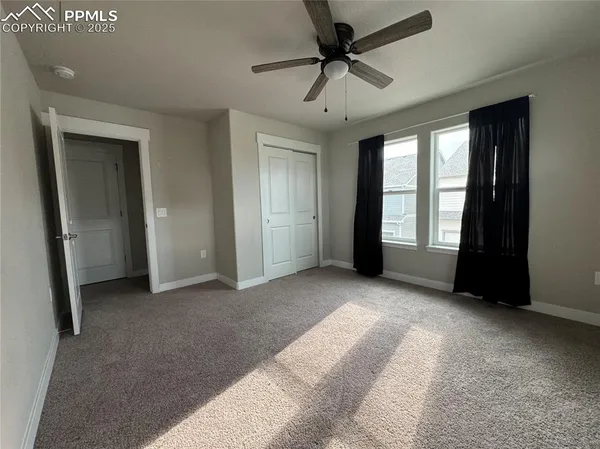 a view of a livingroom with a ceiling fan and window