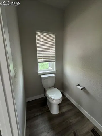 a white toilet sitting next to a window