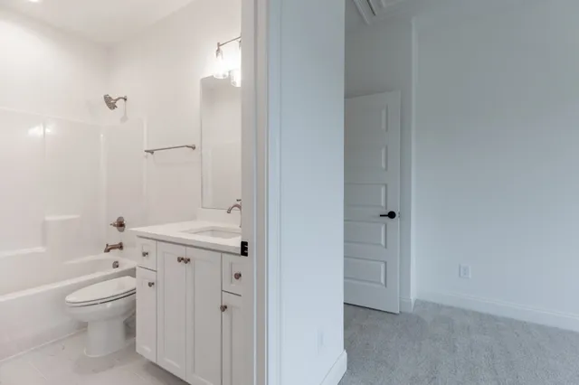 a bathroom with a granite countertop sink a toilet and shower