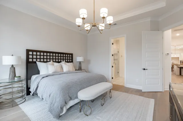 a spacious bedroom with a bed and a chandelier