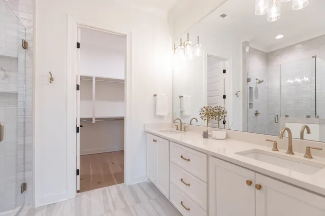 a bathroom with a double vanity sink mirror and shower