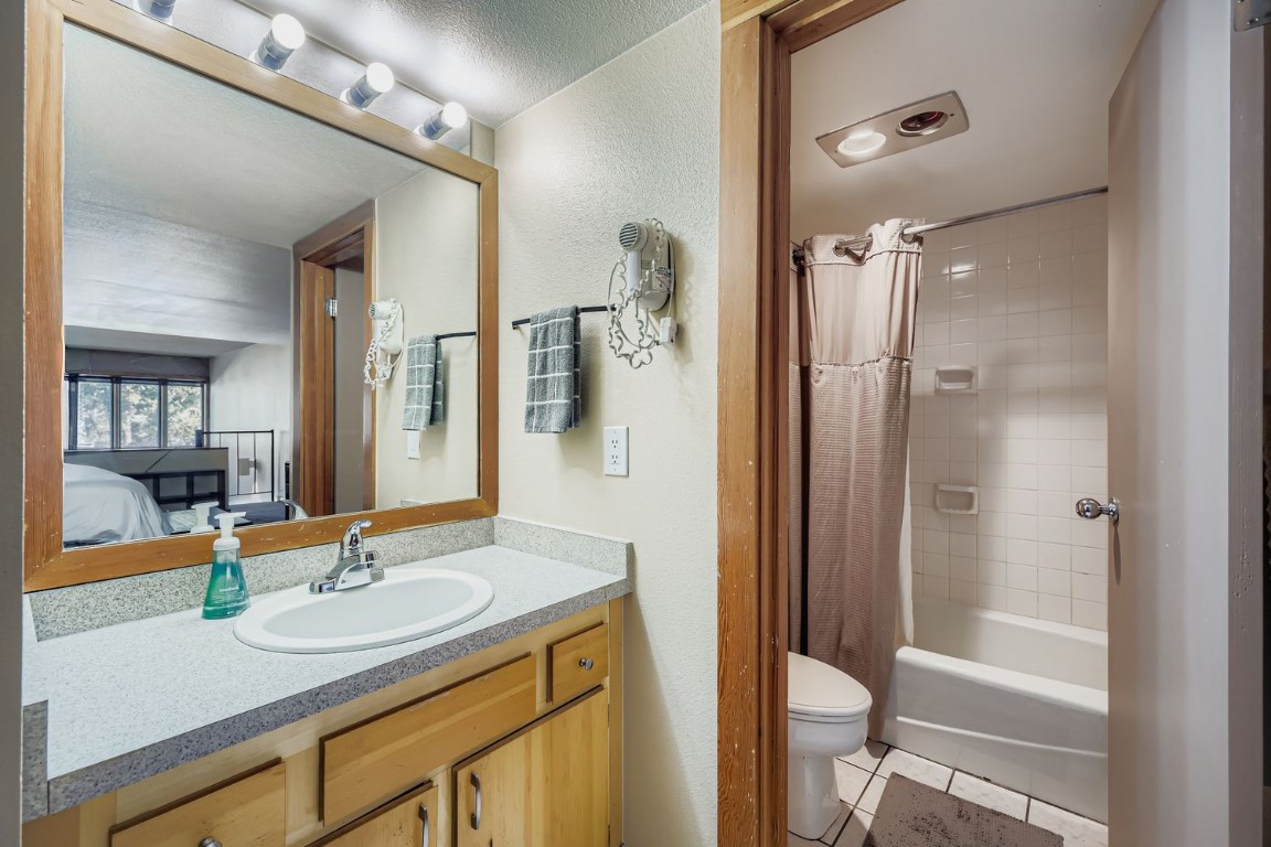 22340 Highway 6, Unit 1784 Keystone, CO 80435 - Photo 13 of 28 a bathroom with a granite countertop sink shower mirror and toilet