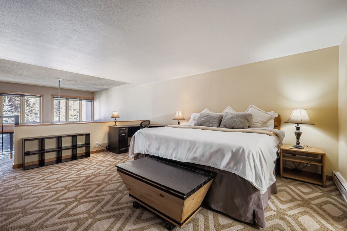 22340 Highway 6, Unit 1784 Keystone, CO 80435 - Photo 10 of 28 a bedroom with a bed and wooden floor