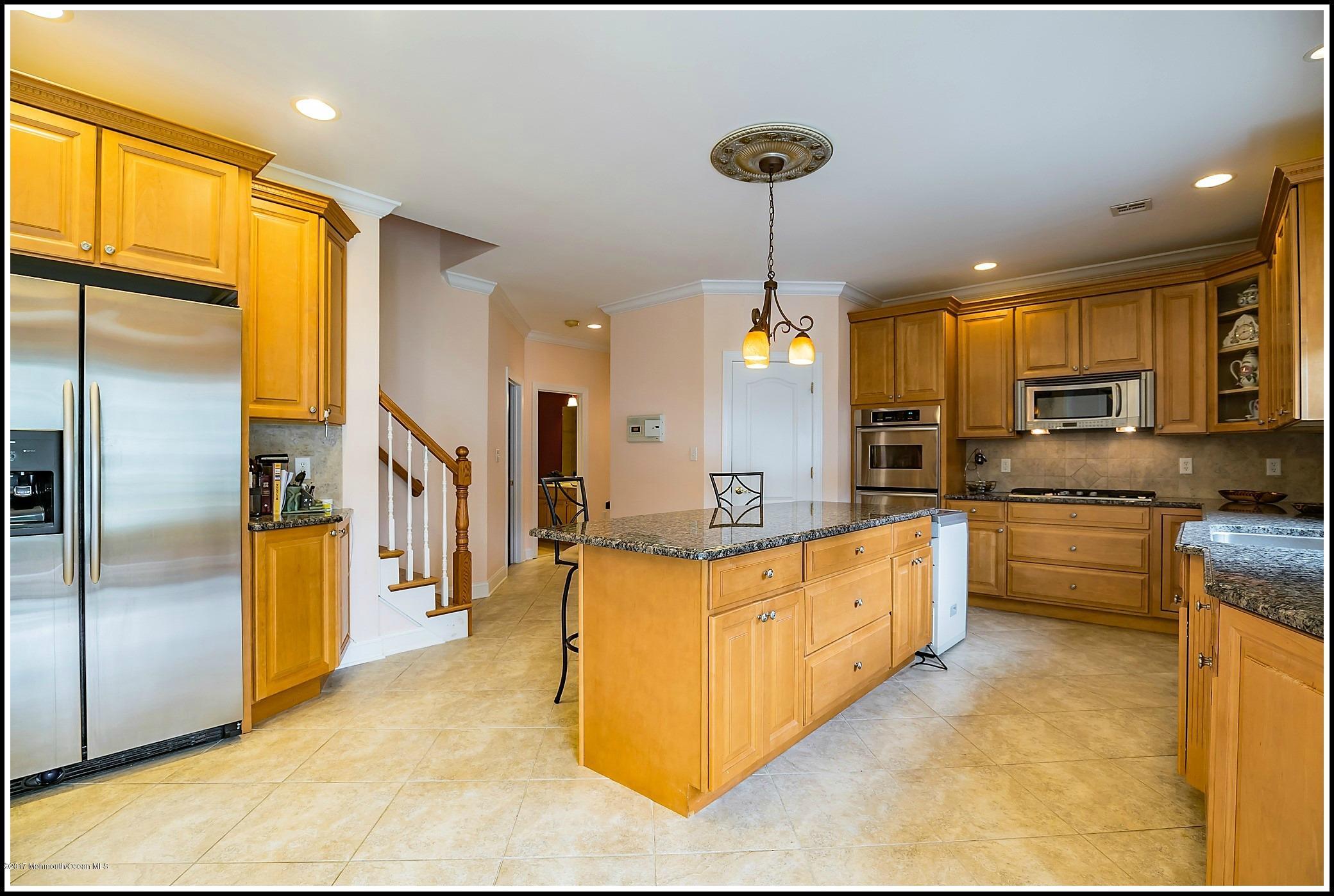 198 Robertsville Road Freehold, NJ 07728 - Photo 11 of 30 a large kitchen with stainless steel appliances kitchen island granite countertop a refrigerator a oven a sink and a counter space
