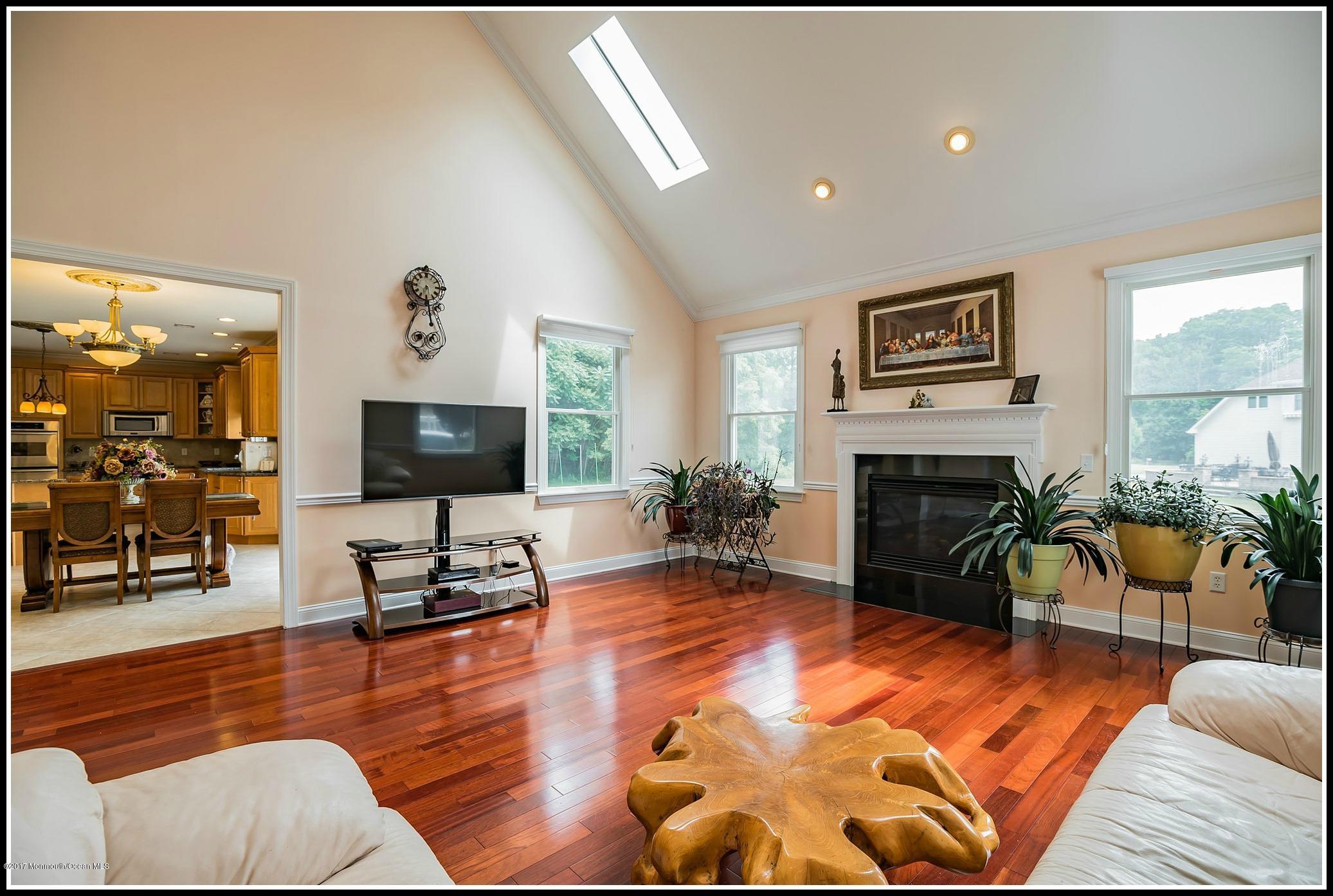 198 Robertsville Road Freehold, NJ 07728 - Photo 5 of 30 a living room with furniture a flat screen tv and a fireplace