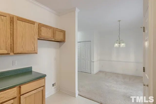 a view of a kitchen with white cabinets and wooden floor