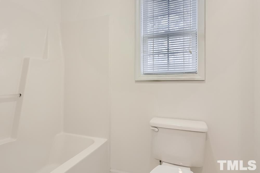 205 Bridgepath Drive Cary, NC 27513 - Photo 21 of 28 a bathroom with a bathtub and a toilet