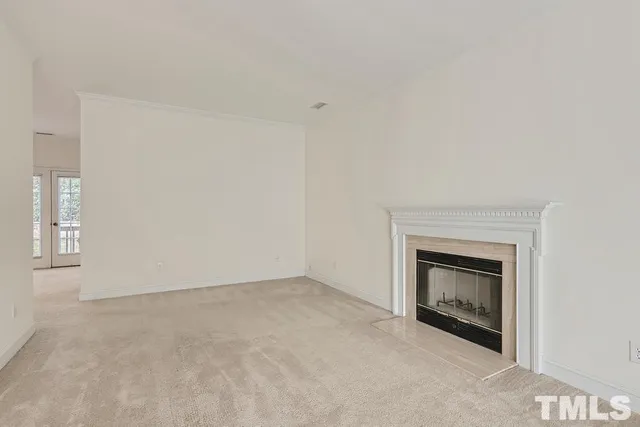an empty room with a fireplace and a window