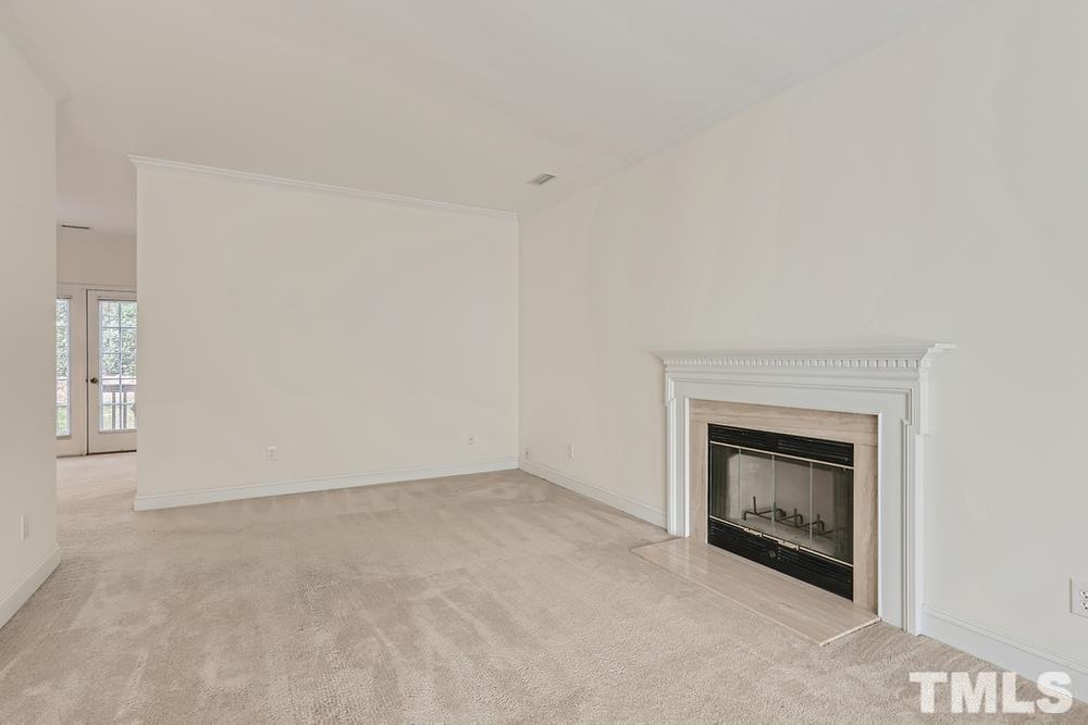 205 Bridgepath Drive Cary, NC 27513 - Photo 7 of 28 an empty room with a fireplace and a window